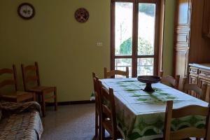 a dining room with a table and chairs and a window at Il canto del gallo casa vacanza in Cassinasco