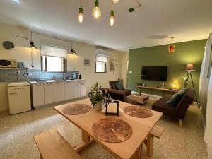 uma sala de estar com uma mesa e uma cozinha em Casa Camellia metula em Metulla