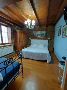- une chambre avec un lit et un lustre dans l'établissement Hotel Rural El Angel de la Guarda, à Güemes
