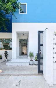 a black door on a white building with potted plants at The zai Apartment in Ban Krathum Lom