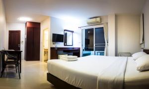 a bedroom with a large white bed and a desk at Sunshine Hostel in Hua Hin