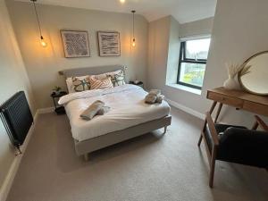 a bedroom with a bed with a mirror and a chair at Caernarfon modern townhouse Snowdonia in Caernarfon