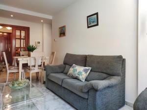 sala de estar con sofá y mesa en Desconectaengalicia Cesteiros, piscina, 100m Playa Silgar, en Sanxenxo