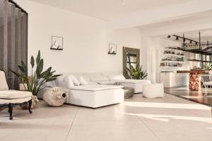 a white living room with a white couch and chairs at Liostasi in Ios Chora