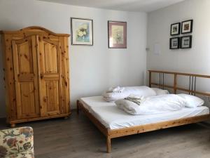 um quarto com 2 camas e um armário de madeira em Három Tarka Macska Apartmanok em Sárospatak