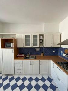 a kitchen with white cabinets and a blue and white checkered floor at Apartmán Obchodná in Staré Mesto
