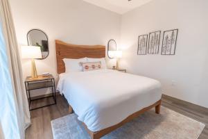 a bedroom with a large white bed and two mirrors at Colony Suites in Palmer