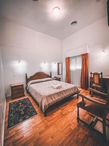 een slaapkamer met een bed en een houten vloer bij Hotel Americano in Buenos Aires