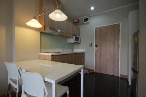 a kitchen with a white table and white chairs at Sereine Sukhumvit 39 in Bangkok