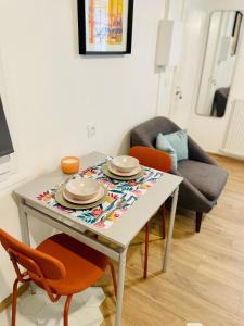 a table with plates and bowls on it in a living room at STUDIO Retro MARAIS- Paris Center in Paris