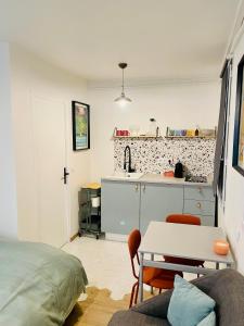 a living room with a table and a kitchen at STUDIO Retro MARAIS- Paris Center in Paris