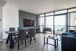 a living room with a table and a blue couch at Luxury Two Bedroom Seaview Apt in Bat Yam