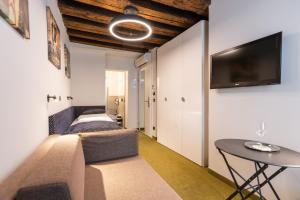 Zimmer mit 2 Betten, einem Tisch und einem TV in der Unterkunft Boutiquehotel am Dom in Salzburg