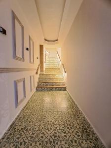 un largo pasillo con una escalera con un suelo estampado en Hotel Casa Agustina en Cartagena de Indias