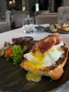 a plate of food with bacon and eggs on a table at Готельно-ресторанний комплекс Щастя in Poltava