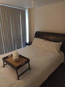 萊斯特的住宿－City Center Leicester，一张带木制托盘的床铺,上面有毛巾