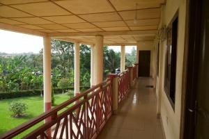 a wooden balcony with a view of a garden at Sign of Silence Hostel in Kumasi