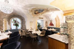 a restaurant with tables and chairs in a room at Boutiquehotel am Dom in Salzburg