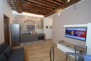 cocina y sala de estar con TV en la pared en VICO DURAZZO APARTMENT, en Génova
