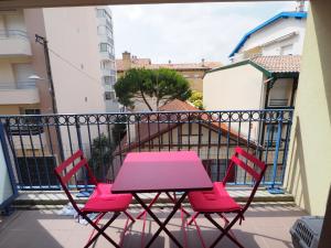 アルカションにあるAppartement Arcachon, 2 pièces, 2 personnes - FR-1-474-38のピンクのテーブルとバルコニー(椅子2脚付)