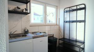 a small kitchen with a sink and a window at Mivano-Apartments WiFi Küche NETFLIX in Celle