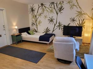 Sala de estar con cama, silla y TV en Stay Apartment Hotel, en Karlskrona