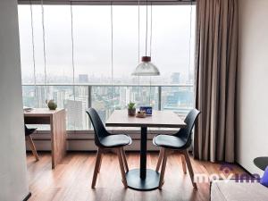 a dining room with a table and chairs in front of a window at River One - Butantã in São Paulo