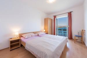 1 dormitorio con 1 cama y vistas al océano en Apartmani Ivušić en Dubrava