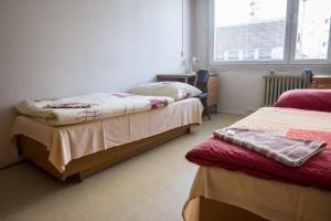 1 dormitorio con 2 camas y ventana en Apartments Kolej Vltava, en Praga