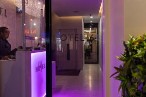 un magasin avec un panneau lumineux violet sur la porte dans l'établissement Hotel 64 Nice, à Nice