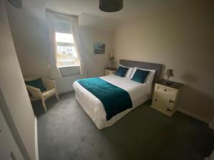 a bedroom with a bed and a chair and a window at Suantrai Accommodation in Doolin