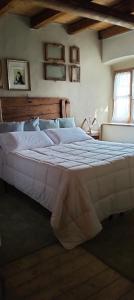 uma grande cama branca num quarto com tecto em madeira em La Casa di Marla em Sirmione