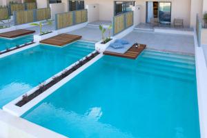 an infinity pool with benches in a house at Cora Hotel & Spa in Afitos