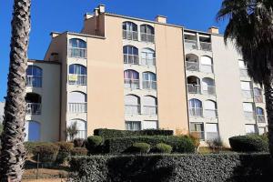 duży budynek z krzakami przed nim w obiekcie Appartement avec parking Cap d'Agde, La Falaise w Cap d'Agde