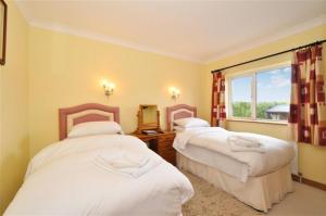 a hotel room with two beds and a window at Claremount House B&B in Galway