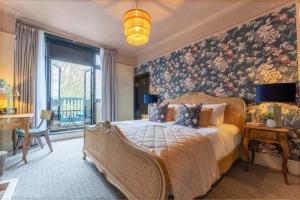 a bedroom with a large bed with a floral wallpaper at The Crown Inn in Bromley