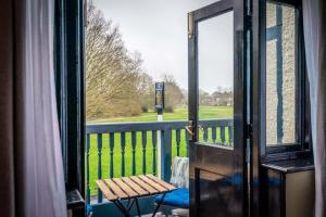 a balcony with a wooden bench and a window at The Crown Inn in Bromley