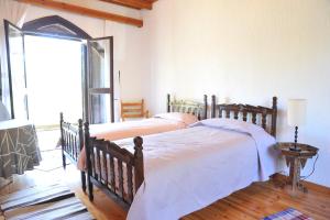 a bedroom with two beds and a large window at CASA IRENE in Kakopetria