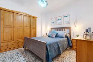 a bedroom with a bed and a wooden cabinet at Casa Turquesa in Tamaraceite