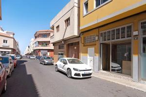a white car parked on a street next to buildings at Casa Turquesa in Tamaraceite
