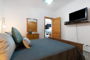 a bedroom with a bed and a flat screen tv at Casa Turquesa in Tamaraceite