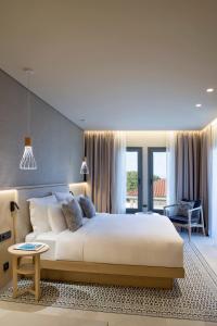 a bedroom with a large white bed in a room at Cora Hotel & Spa in Afitos