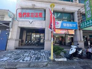 花蓮市的住宿－咩咩不是羊民宿Mieh's Inn 花蓮市區 電梯 寵物友善民宿，停在前面的摩托车建筑