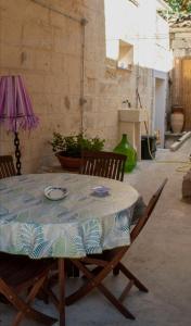 a table with two chairs and a table cloth on it at La Maison d'Eugenia in Casamassella