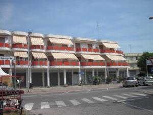 リド・デッレ・ナツィオーニにあるAppartamenti Ponenteの通りに面したオレンジと白のバルコニー付きの建物
