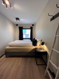 Schlafzimmer mit einem Bett und einem Fenster in der Unterkunft Notodden Sentrum Apartment NO 11 in Notodden