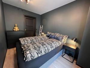 Schlafzimmer mit einem Bett mit einer schwarzen und weißen Bettdecke in der Unterkunft Notodden Sentrum Apartment NO 11 in Notodden