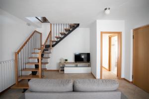 sala de estar con escalera y sofá en IseoLakeRental - Appartamento Iris en Solto Collina
