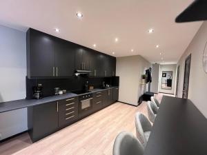uma cozinha com armários pretos e uma mesa e cadeiras em Notodden Sentrum Apartment NO 11 em Notodden