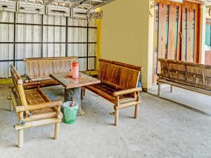 2 bancos de madera y una mesa en una habitación en OYO 92386 Homestay Juwita Perdana Syariah, 
